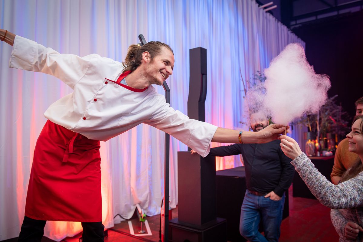 Jérôme tend une barbe à papa à un invité lors d'un événement